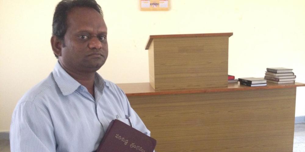 Chadamla, who later changed his name to Samuel, holding his Bible in a chapel at the headquarters of the Adventist Church's South Andhra Section in Ibrahimpatnam, India. (Andrew McChesney / Adventist Mission)