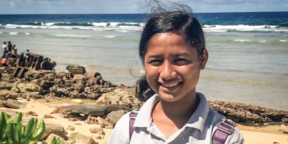 Viona Boro, 16, standing on a Pacific Ocean beach on Ebeye Island. (Andrew McChesney / Adventist Mission)