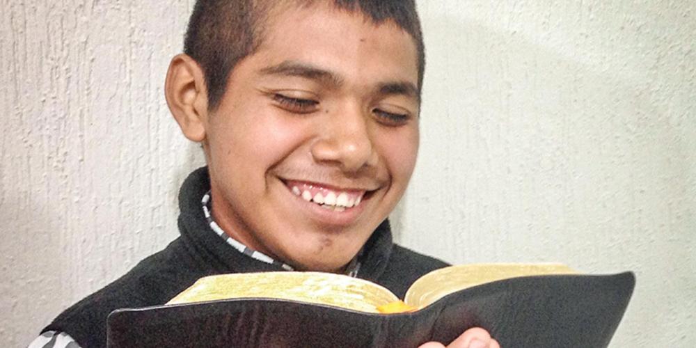 Uriel Arodi Albino Ramos, 15, holding his Bible as he shares his story. Five people have been baptized through his Bible studies. (Andrew McChesney / Adventist Mission)